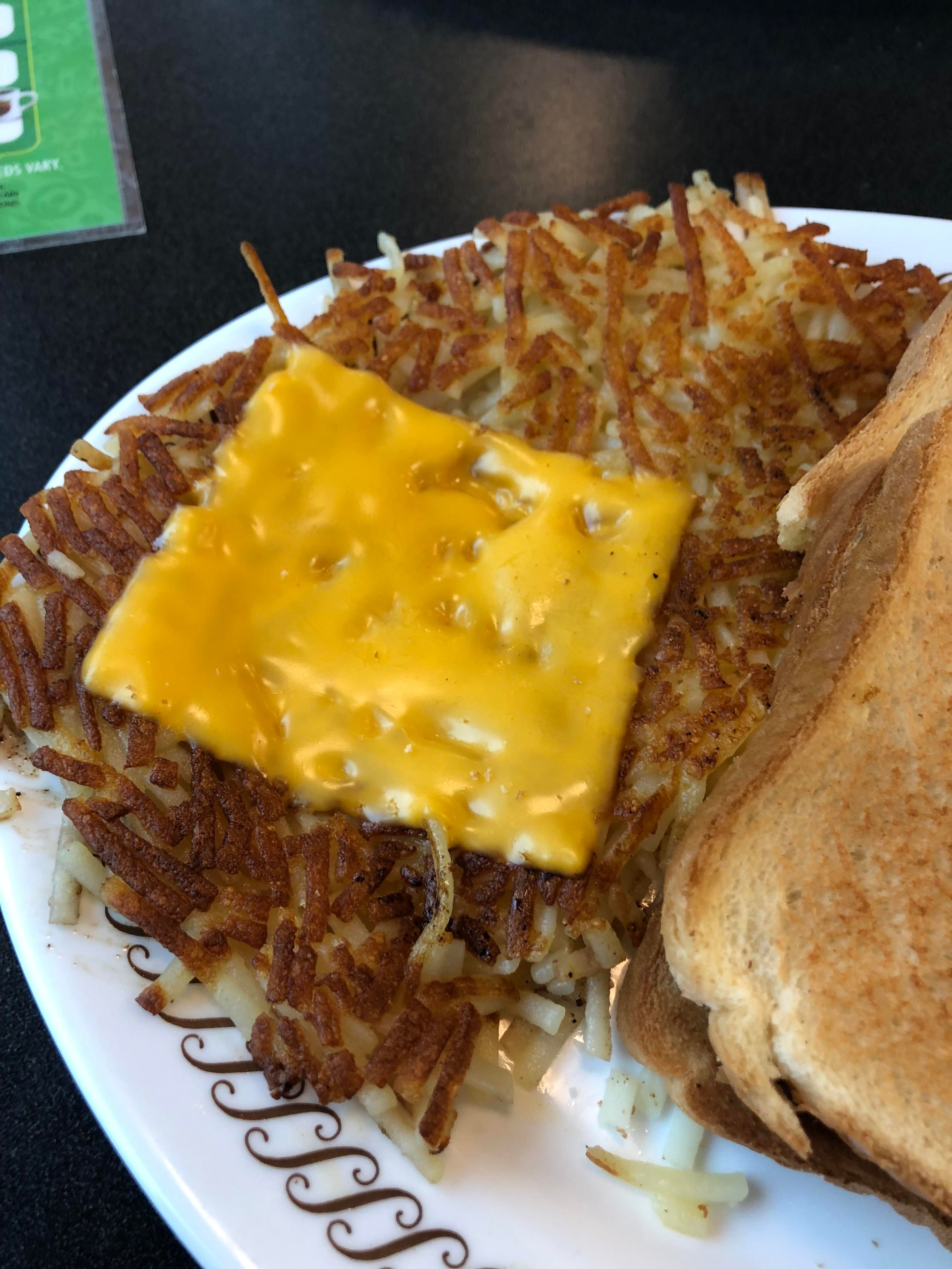 batatas fritas com pedaço de queijo por cima no prato waffle house